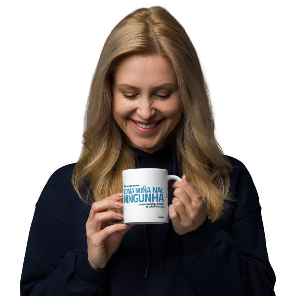 Una mujer sonriente sosteniendo una taza con texto.